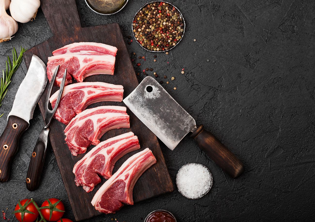 butcher preparing spring lamb cutlets